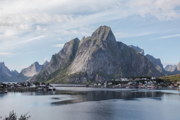 Overlook of a lake with a small village and a mountain in the background