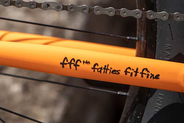 fff ™ fatties fit fine decal on chain stay of orange Surly bike showing part of chain and rear wheel