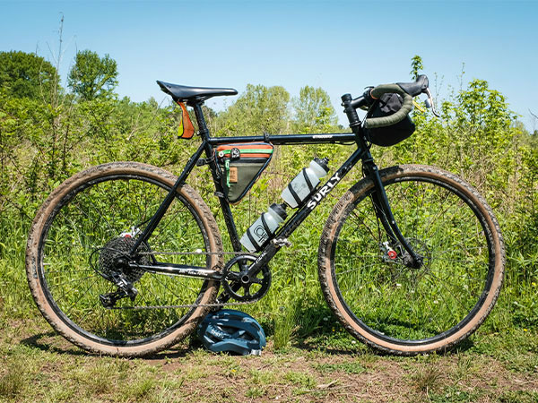 Caz's Surly Straggler with handlebar bag and small frame pack and two water bottle cages side view outside