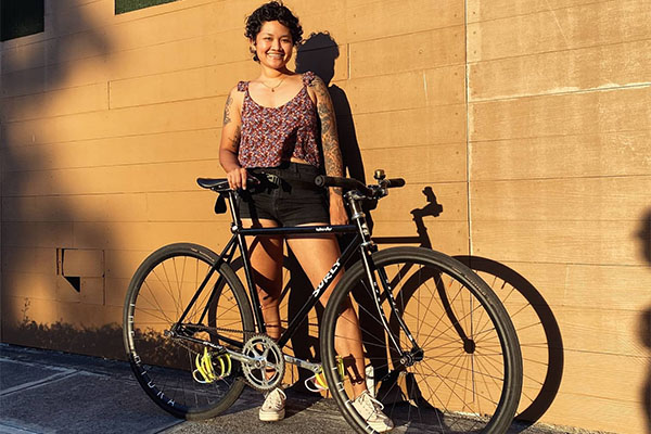 Aneka outside in sun standing behind Surly Steamroller