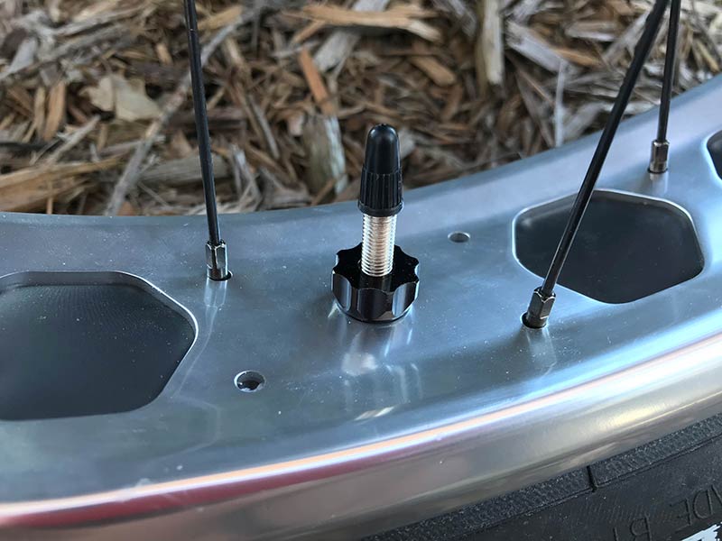 Close up of a Problem Solvers Super P-Nut holding the valve stem on a fat bike rim