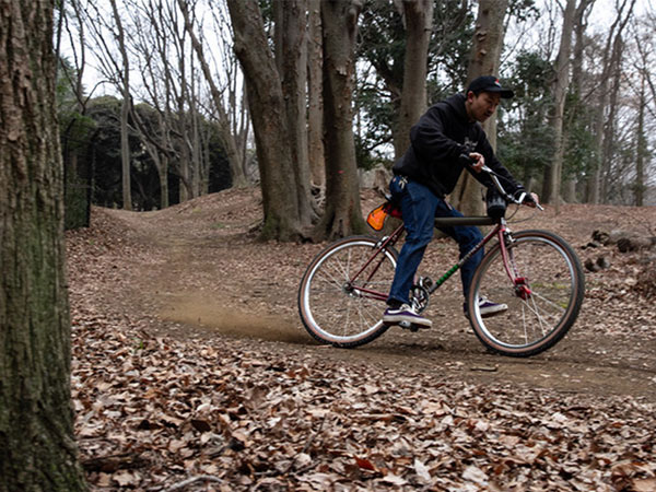 Kaneyan riding on dirt trail in woods skidding rear tire