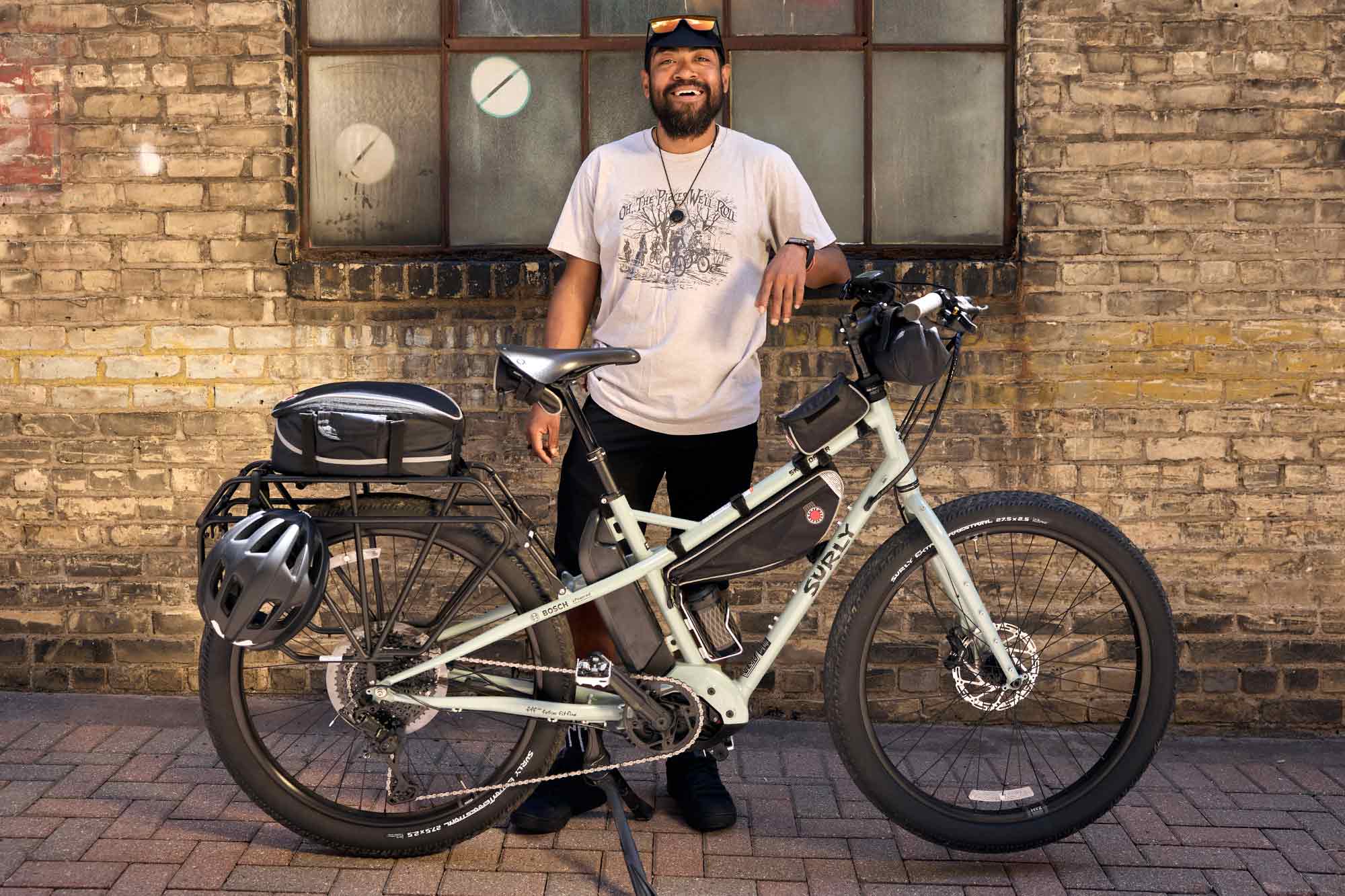 Alexis standing in front of building behind Surly Skid Loader bike smiling