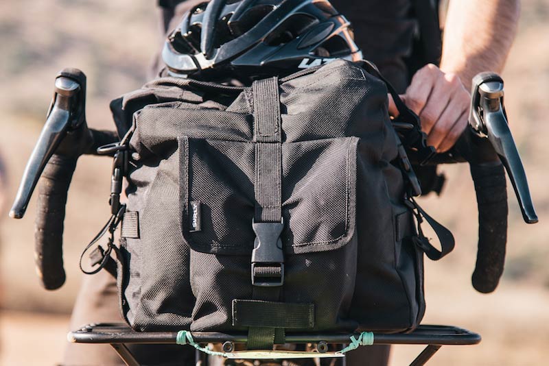 Front close up view of the handlebars with gear bag on a rack of a bike 