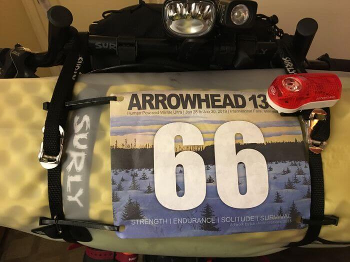 Bike handlebar pack with a light and Arrowhead 135 banner