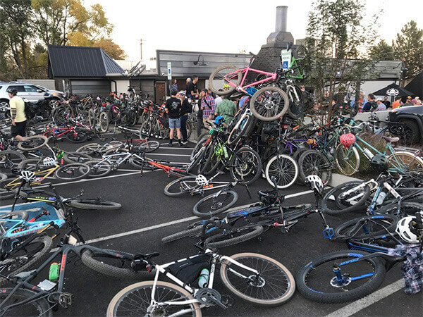 So many bikes parked, stacked upon eachother and laying in and around parking lot