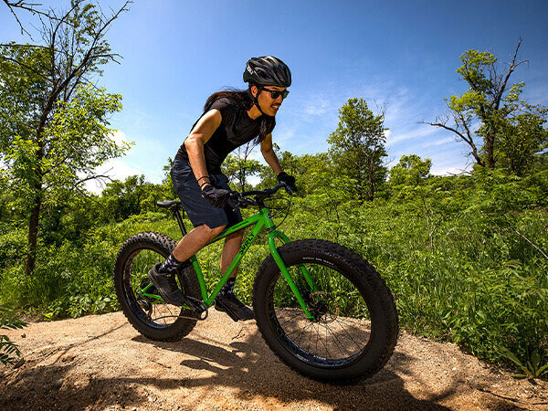 Mountain biker riding Surly Ice Cream Truck on singletrack on sunny day