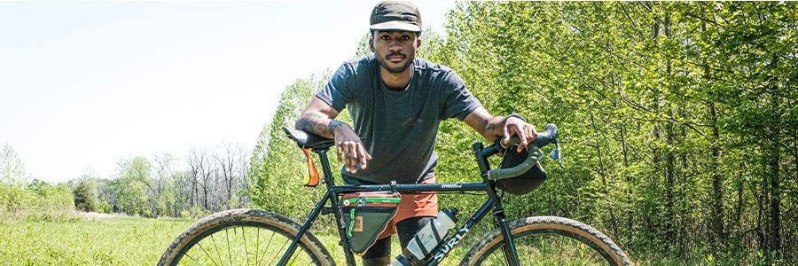 Caz standing behind Surly Straggler in tall grass